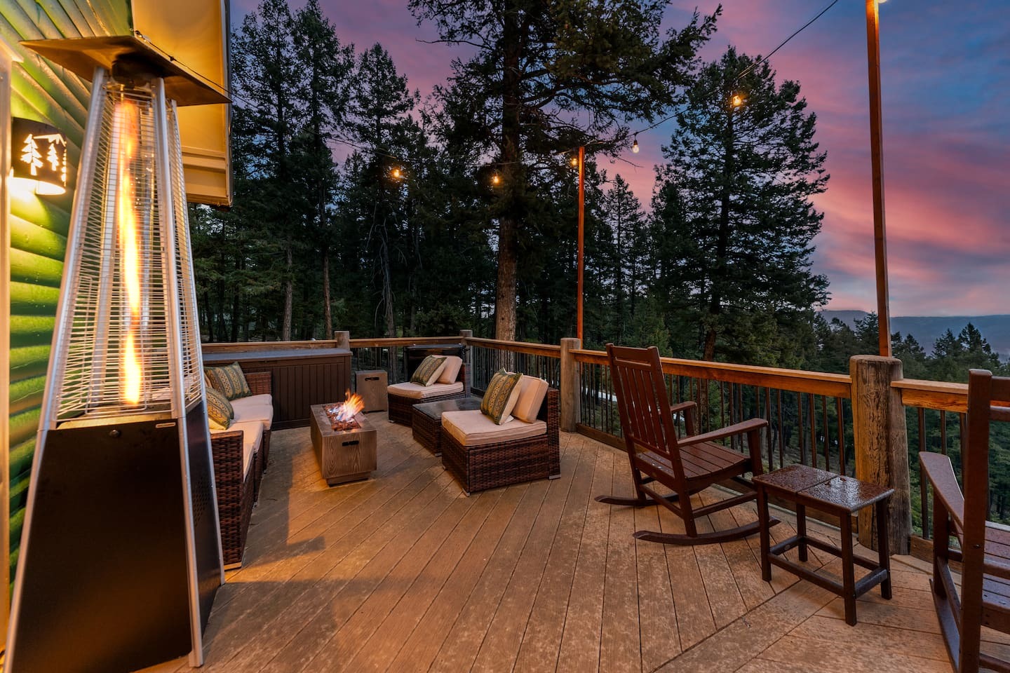Wraparound deck at sunset with heaters, lounge seating and rocking chairs