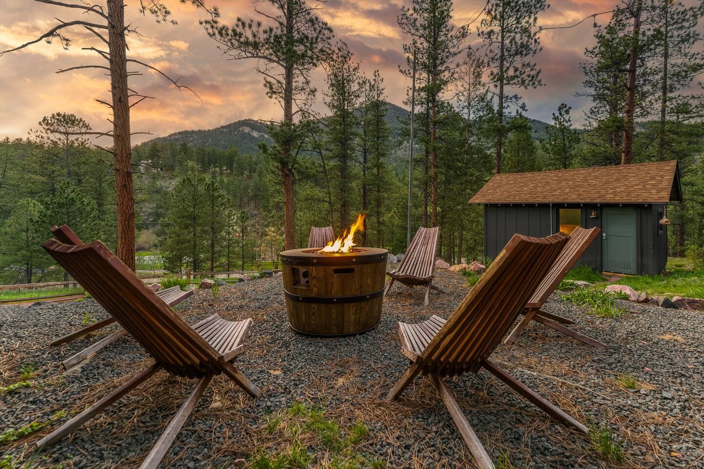 Cozy Cabin’s fire pit with sling chairs at sunset