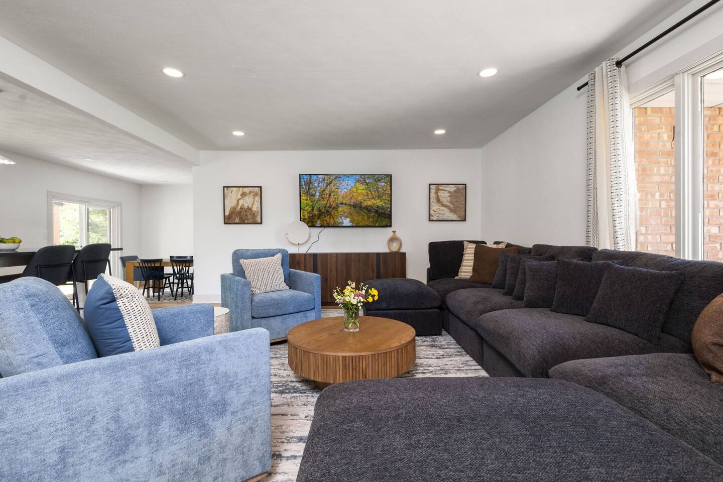 Living room with sectional, armchairs and dining area beyond